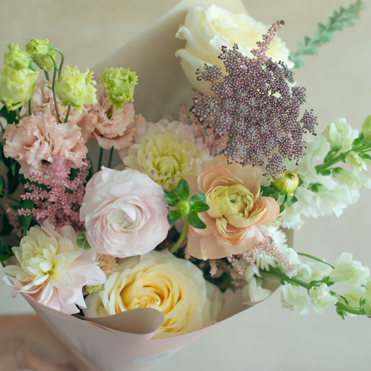 Bouquet of flowers with pink, yellow, and green colors on a light background
