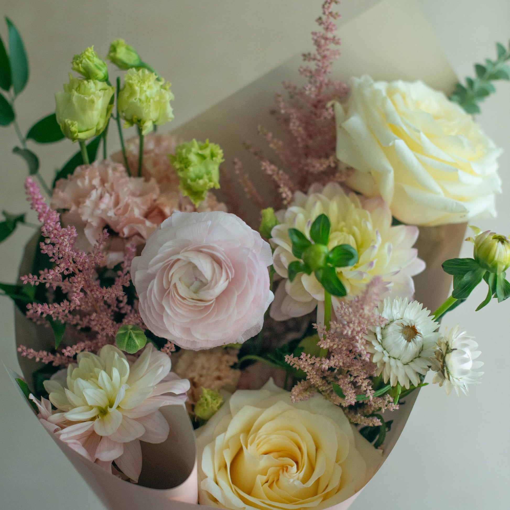 Bouquet of flowers with pink, yellow, and green colors on a neutral background